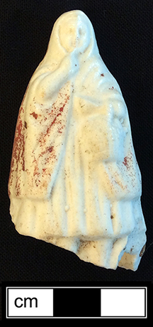 Red riding hood doll, with traces of red paint on the cloak, made of bisque porcelian. 6cm x 2.5cm x 3.25cm - from 18BC27.